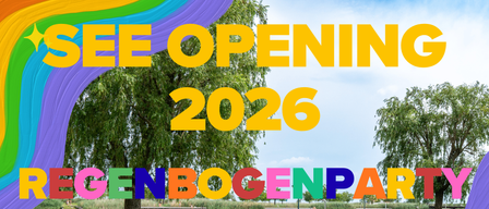 Ein Bild, das die Eröffnung eines Parks im Jahr 2026 bewirbt, zeigt einen Regenbogen und Menschen in einem Rasenbereich in der Nähe eines Gewässers.