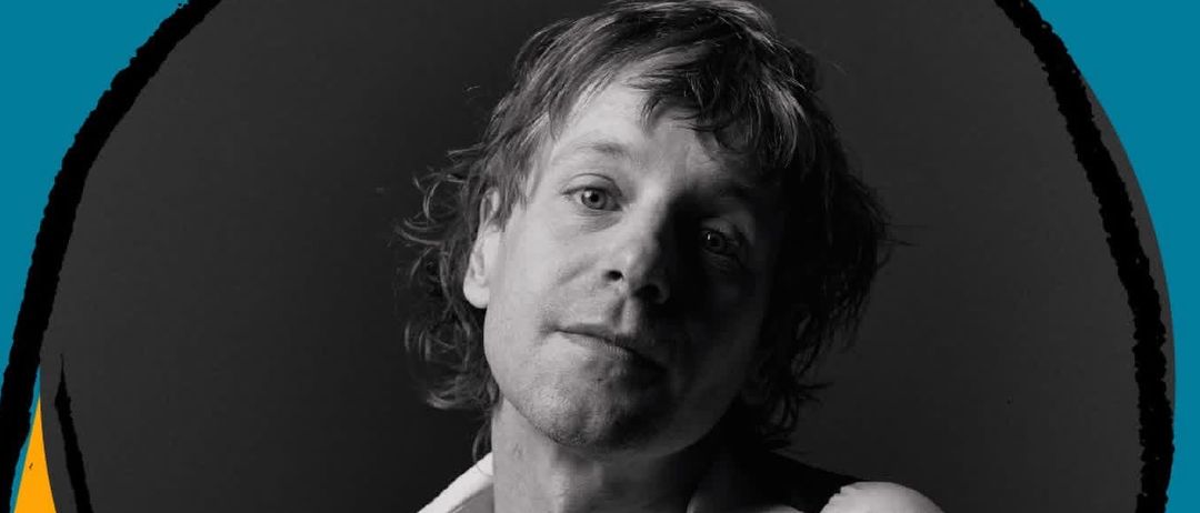 Ein Plakat für eine Veranstaltung mit einem Mann in weißem Hemd und schwarzem Weste. Der Text 'Die Ansa Panier' und 'Sa, 5. Dezember' ist in weiß auf blauem und gelbem Hintergrund.