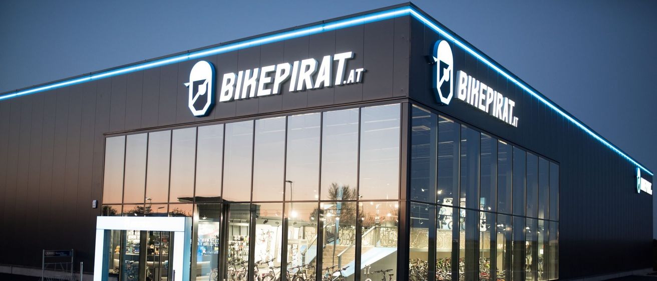 Bild enthält, Car, Car Dealership, Transportation, Vehicle, Architecture, Building, Office Building, Bicycle, Person