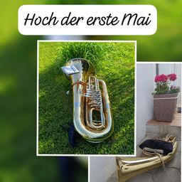 Ein Bild zeigt eine Messingtuba auf dem Rasen mit dem Text 'Hoch der erste Mai' darüber. Rechts ist ein Blumentopf mit roten Blumen zu sehen.