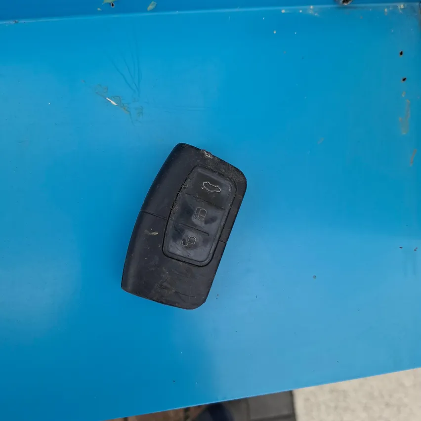 Ein schwarzer Autoschlüssel befindet sich auf einer blauen Oberfläche.