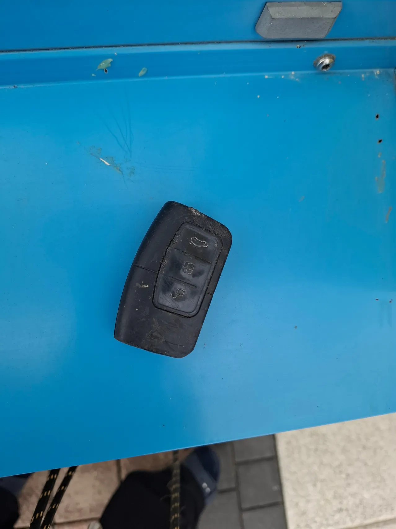 Ein schwarzer Autoschlüssel befindet sich auf einer blauen Oberfläche.