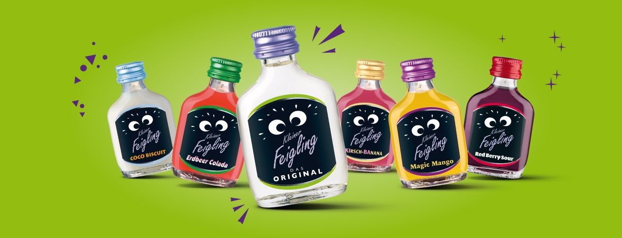 Fünf kleine Flaschen mit farbiger Flüssigkeit. Jede Flasche hat einen anderen Geschmack. Eine Flasche ist klar und die anderen haben farbige Kappen. Sie sind auf einem grünen Hintergrund dargestellt.