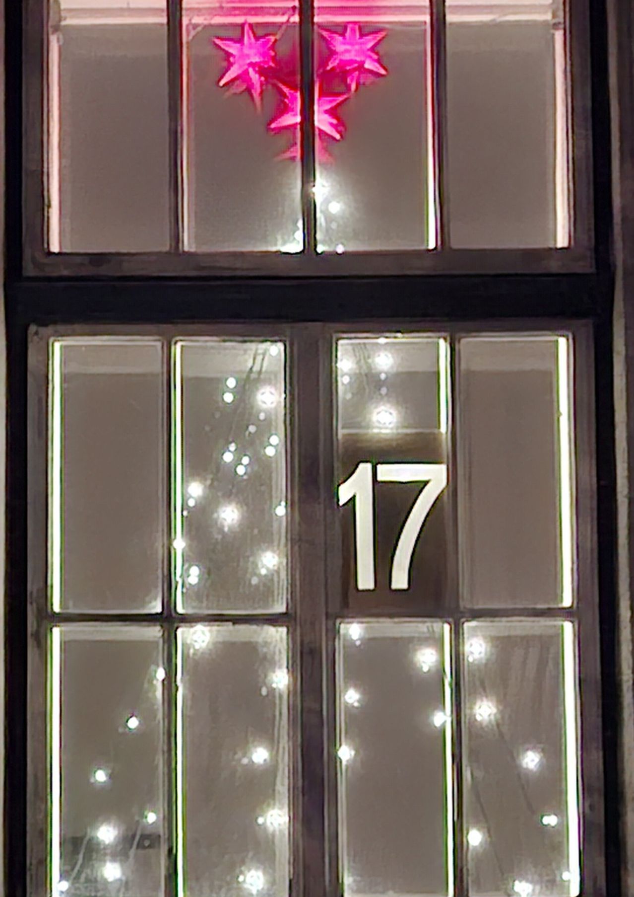 Ein Fenster zeigt die Nummer 17 mit einer Gruppe kleiner Lichter im oberen Fensterteil. Die Fenster sind durch weiße Linien unterteilt.