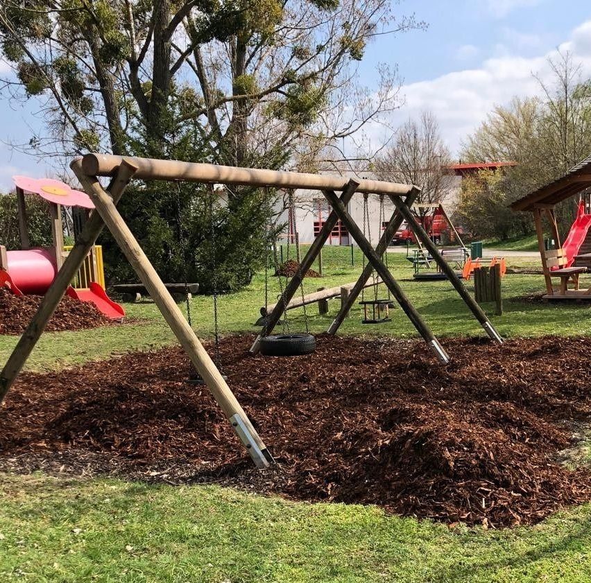 Kinderspielplatz mit Schaukel, Reifen und Rutsche in Österreich
