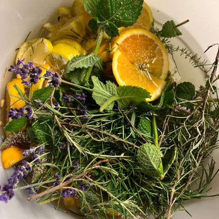 Ein weißer Teller mit frischen Kräutern, Zitronen und Lavendel.