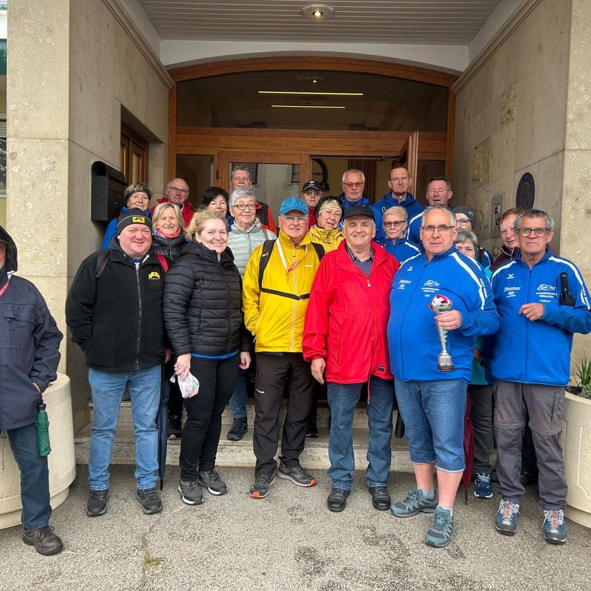 Eine Gruppe von Menschen in Sportbekleidung posiert für ein Foto vor einem Gebäude.
