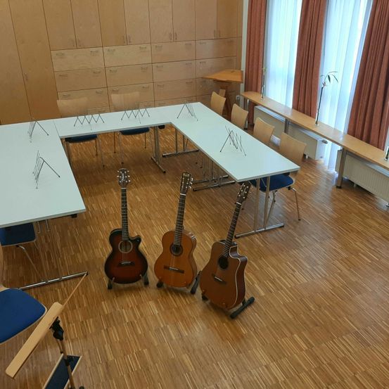 Bild enthält, Indoors, Interior Design, Floor, Wood, Guitar, Furniture, Table, Flooring, Chair, Hardwood