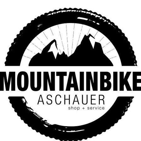 Ein schwarz-weißes Logo für Mountainbike Aschauer, das eine Silhouette eines Fahrradreifens mit Bergspitzen im Inneren zeigt. Unter dem Reifen steht der Text 'Mountainbike Aschauer' und 'Shop + Service'.