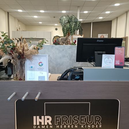 Bild enthält, Indoors, Furniture, Table, Person, Building, Foyer, Hardware, Monitor, Screen, Clapperboard