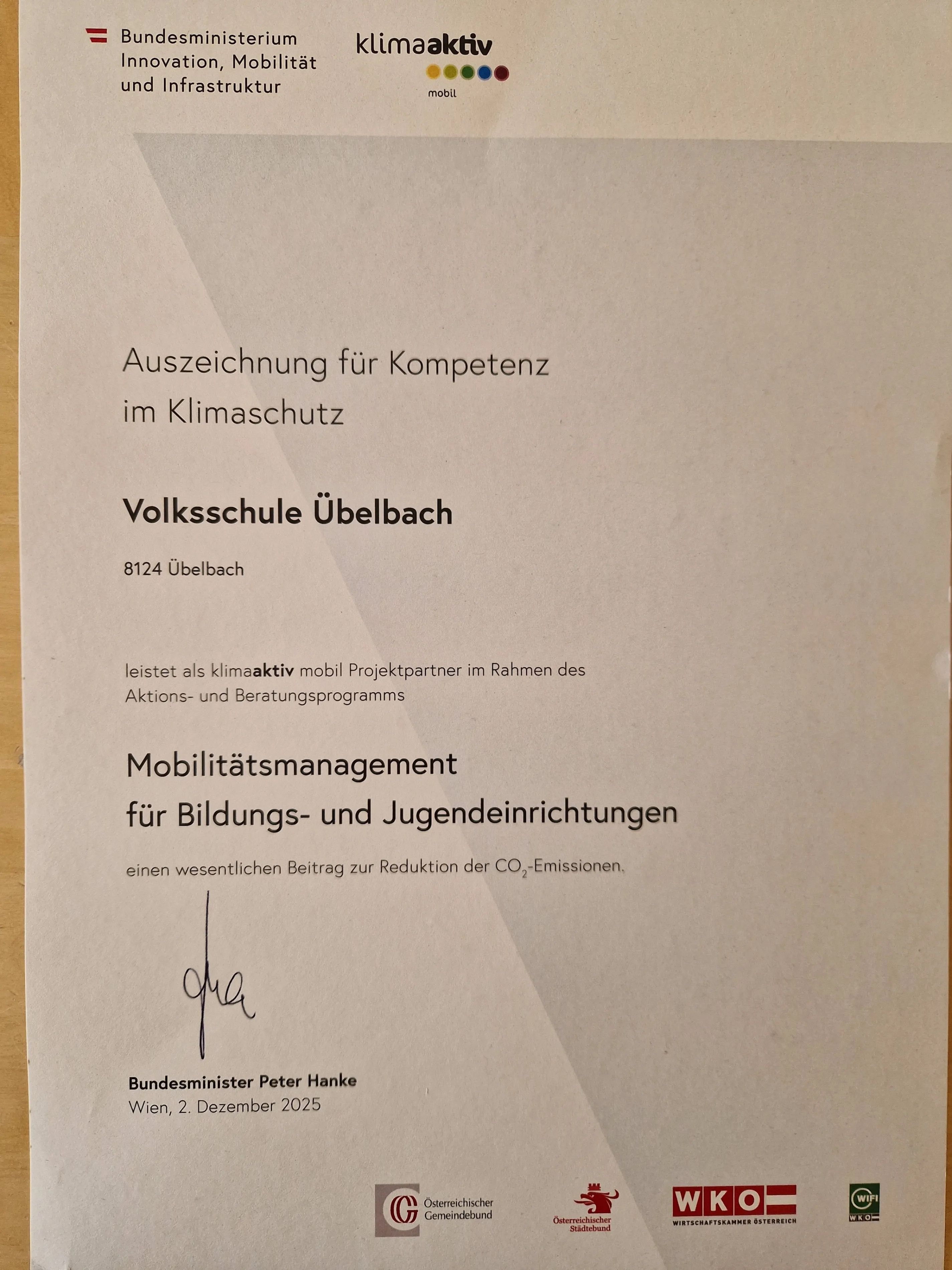 Ein Zertifikat für Kompetenz im Klimaschutz. Die Volksschule Uebelbach in Uebelbach würdigt einen wesentlichen Beitrag zur CO2-Reduktion. Unterzeichnet von Peter Hanke, Bundesminister, am 2. Dezember 2025.