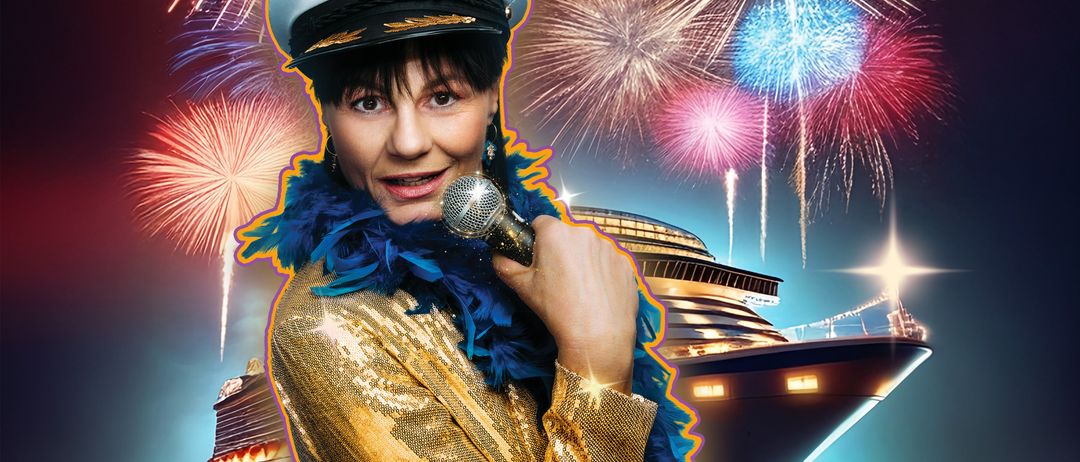 Eine Frau in einem goldenen Kostüm hält ein Mikrofon, mit Feuerwerk im Hintergrund und einem Kreuzfahrtschiff, das in der Ferne beleuchtet ist.
