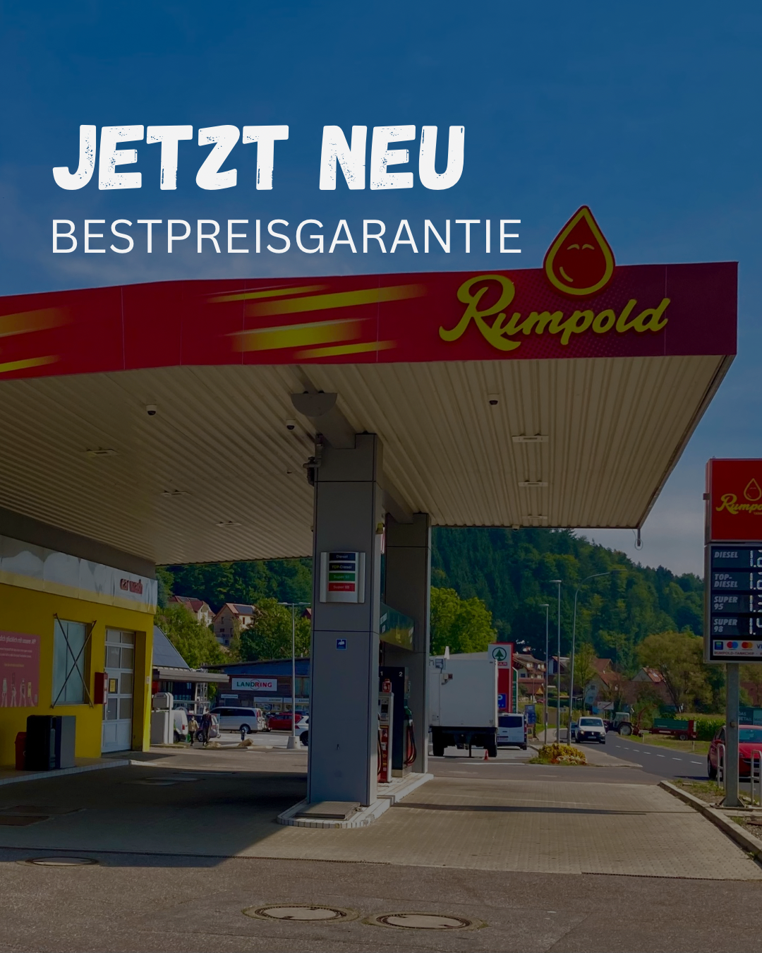 Eine Außenszene einer Rumpolda-Tankstelle mit einem Preisschild und einem Tanklastwagen vor der Tür. Der Himmel ist blau und in der Ferne stehen Autos und Häuser.