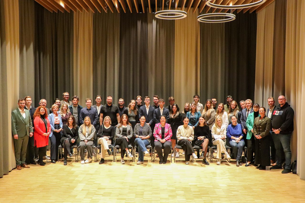 Bild enthält, Groupshot, Person, People, Crowd, Clothing, Coat, Indoors, Suit, Classroom, Shoe