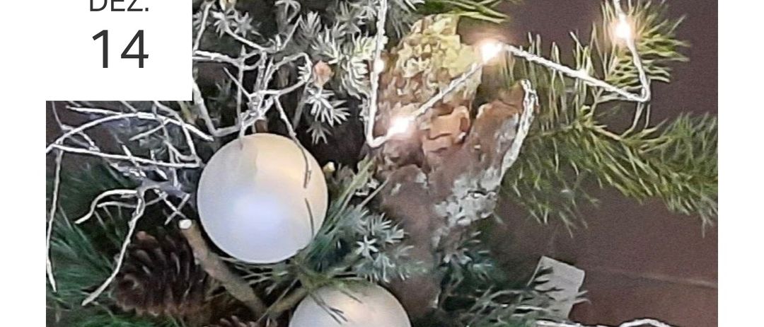 Ein Nahaufnahme einer Weihnachtsbaumdekoration mit weißen Kugeln, grünen Blättern und Lichterketten. Die Kugeln sind glänzend und rund.