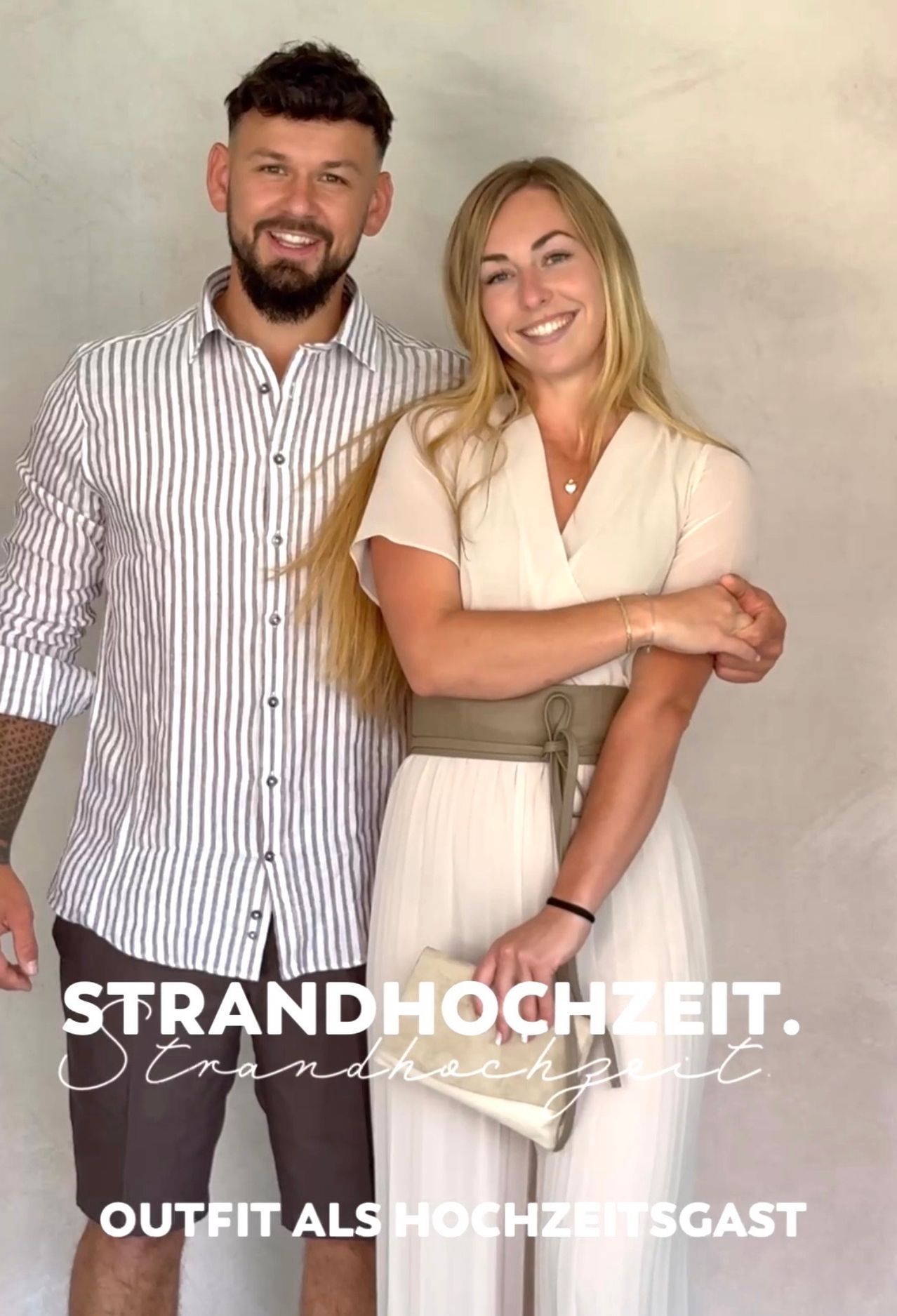 Ein Mann und eine Frau stehen eng beieinander und lächeln. Er trägt ein gestreiftes Hemd, sie ein weißes Kleid mit einem braunen Gürtel. Sie posieren vor einer hellen Wand. Der Text lautet 'Strandhochzeit'.