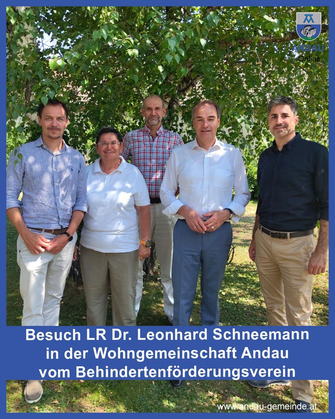 Fünf Personen stehen unter einem Baum mit grünen Blättern. Der Mann links trägt ein gestreiftes Hemd und eine Hose. Die Frau in der Mitte trägt eine Brille und ein weißes Hemd. Der Mann in der Mitte trägt ein weißes Langarmhemd und eine blaue Hose. Der Mann rechts trägt ein schwarzes Hemd und eine Khakihose.