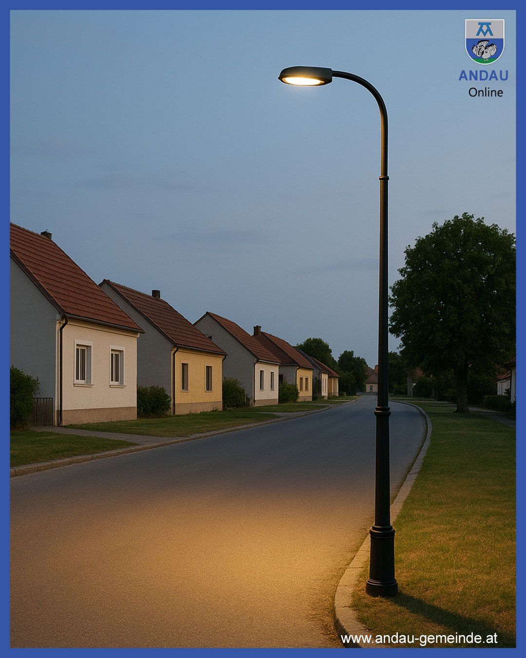 Eine beleuchtete Straßenlaterne steht am Straßenrand neben Häusern und Bäumen. Das Bild hat einen blauen Rand und einen Wasserzeichen.