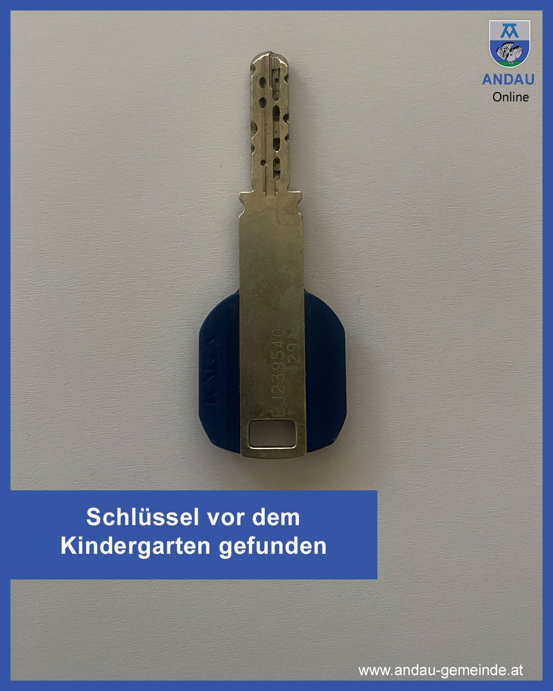 Ein Schlüssel mit einer blauen Abdeckung ist an einer Wand befestigt. Darunter steht 'Schlüssel vor dem Kindergarten gefunden'. In der oberen rechten Ecke steht 'ANDAU Online'.