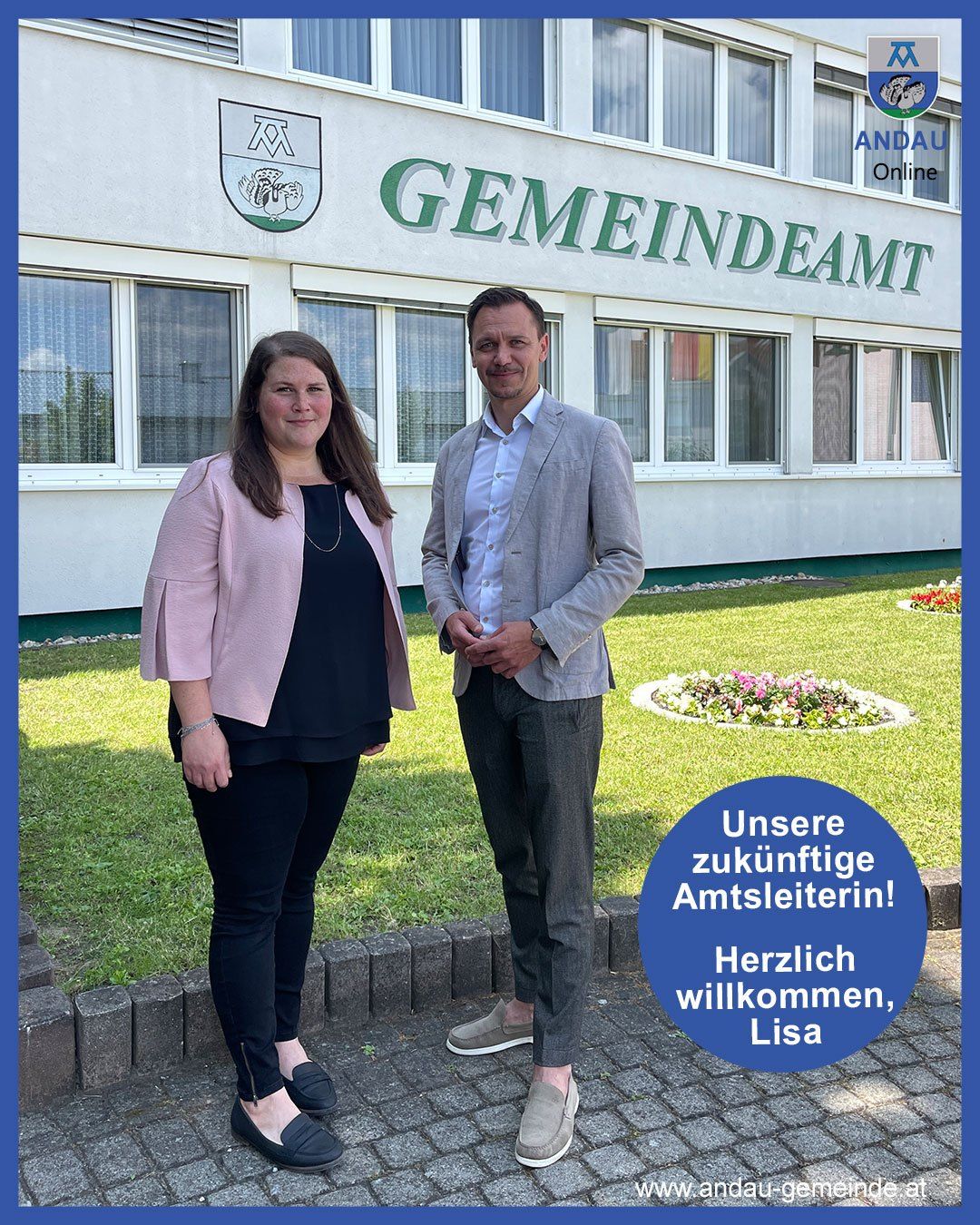 Zwei Personen stehen vor dem 'GemeinDeAmt' Gebäude. Eine Frau lächelt mit einer Halskette und einem Armband. Ein Mann steht mit einer Uhr und zusammengefalteten Händen.