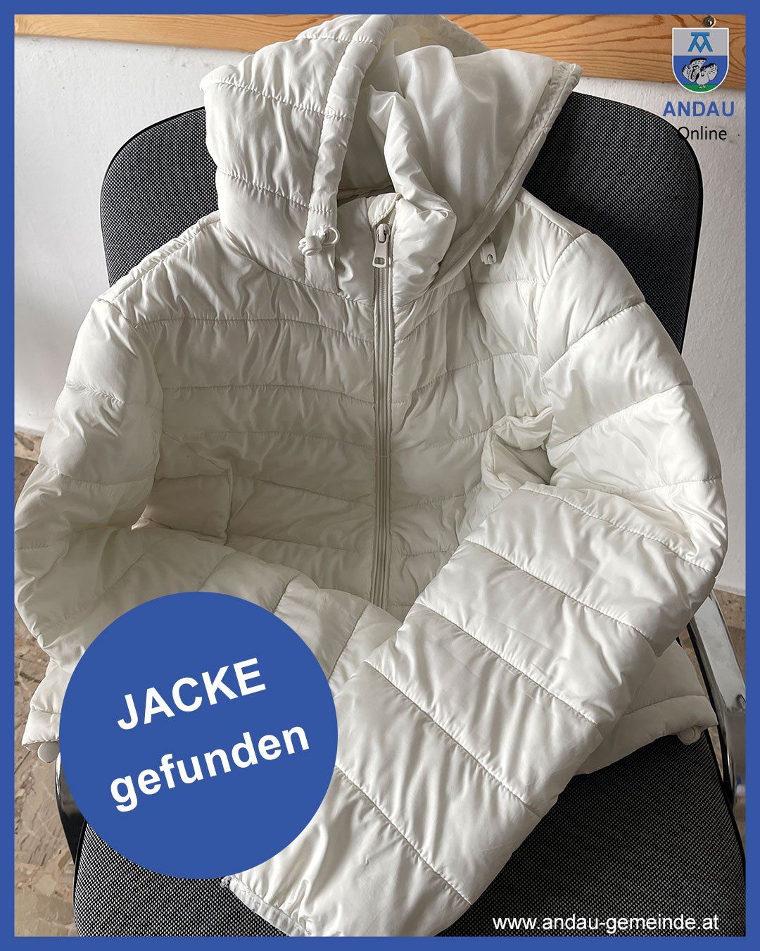 A white puffer jacket with a hood is displayed on a black chair. The jacket is folded neatly and has a blue circle with text.