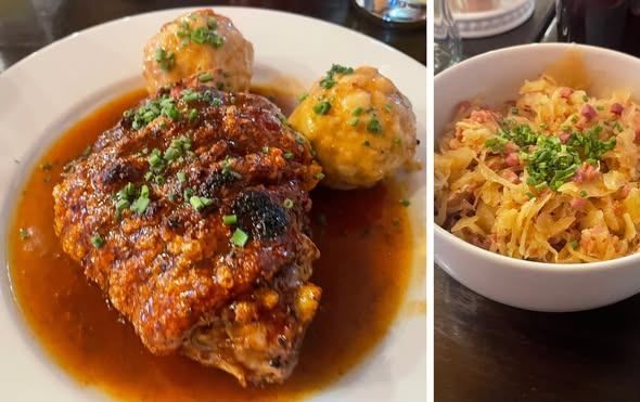 Zwei Gerichte auf Tellern: ein Fleischgericht mit Soße und zwei Knödeln und eine Schüssel Sauerkraut mit Schinken und Schnittlauch.