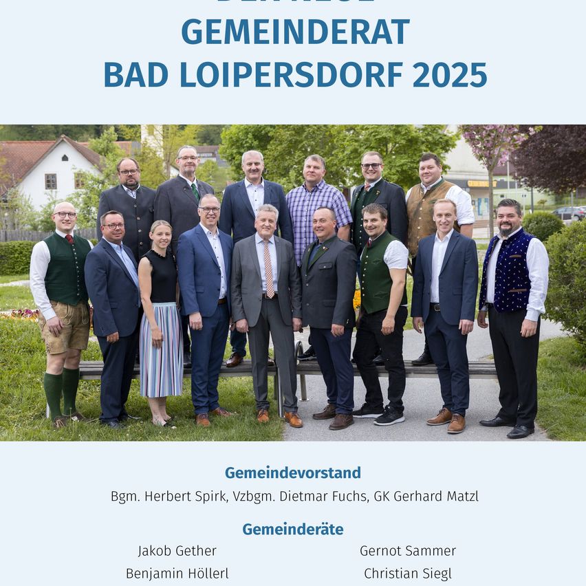 Eine Gruppe von Männern und Frauen in formeller Kleidung steht vor einem Banner mit den Worten Gemeinderat Bad Loipersdorf 2025. Sie stehen auf dem Rasen und posieren möglicherweise für ein Foto.