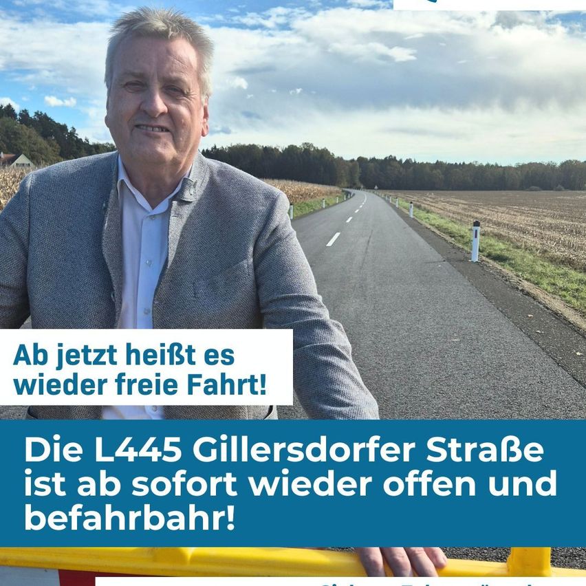 Ein Mann steht lächelnd neben der L445 Gillersdorfer Straße mit dem Text 'Ab jetzt heißt es wieder freie Fahrt!' und 'Die L445 Gillersdorfer Straße ist ab sofort wieder offen und befahrbar!' im Bild.