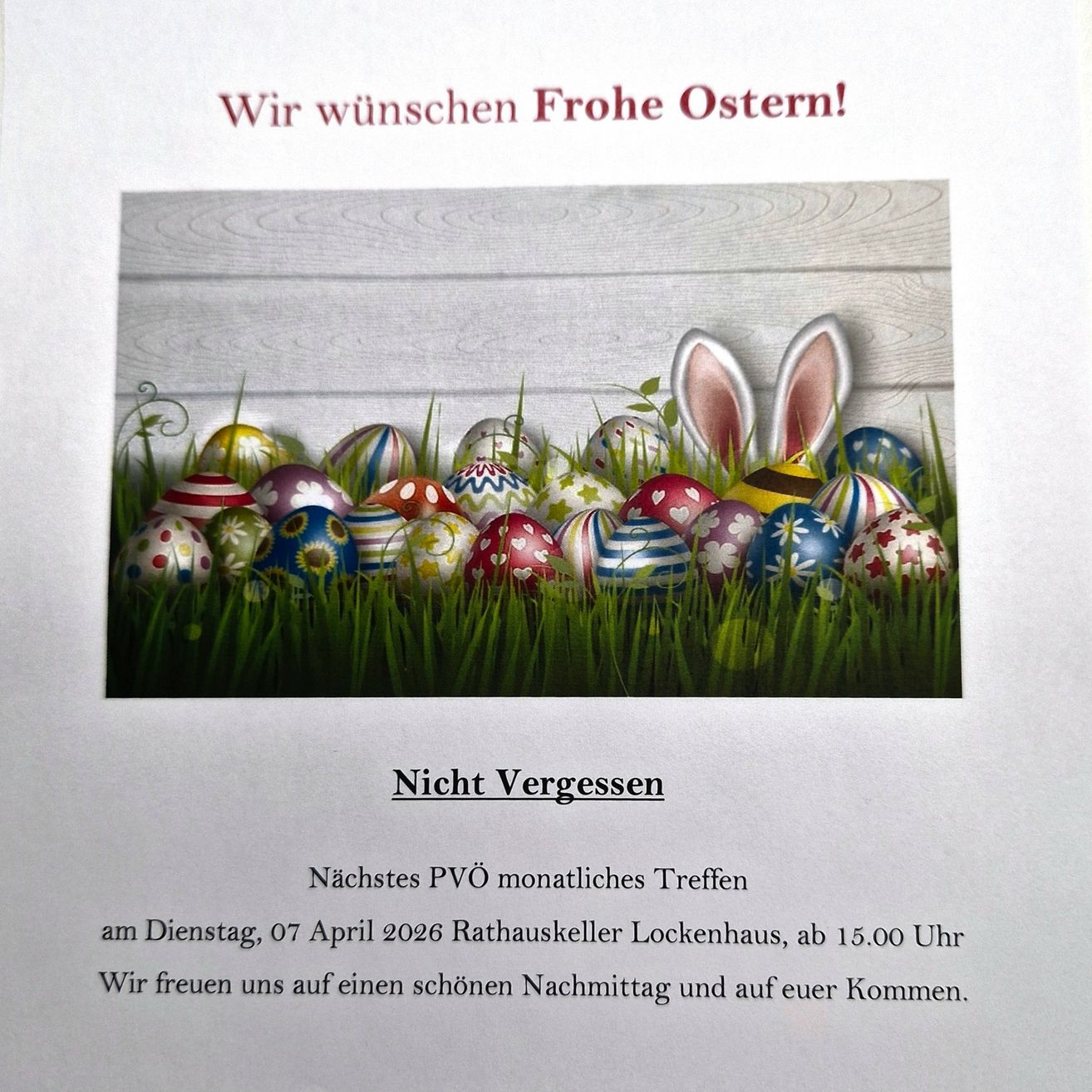 Postkarte mit einem Hasen, bunten Ostereiern im Gras, 'Frohe Ostern!' in Rot, 'Nicht vergessen' darunter, mit einer Erinnerung an das Treffen am 07. April 2026 um 15.00 Uhr.