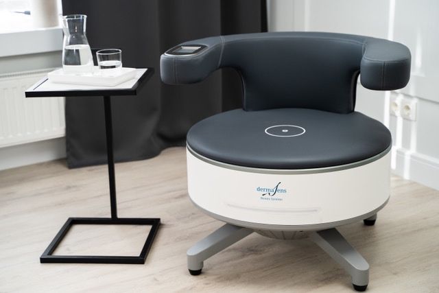 Ein moderner Stuhl mit weißem und schwarzem Design und dem Wort dermasens darauf, neben einem Tisch mit einer Karaffe und zwei Gläsern.