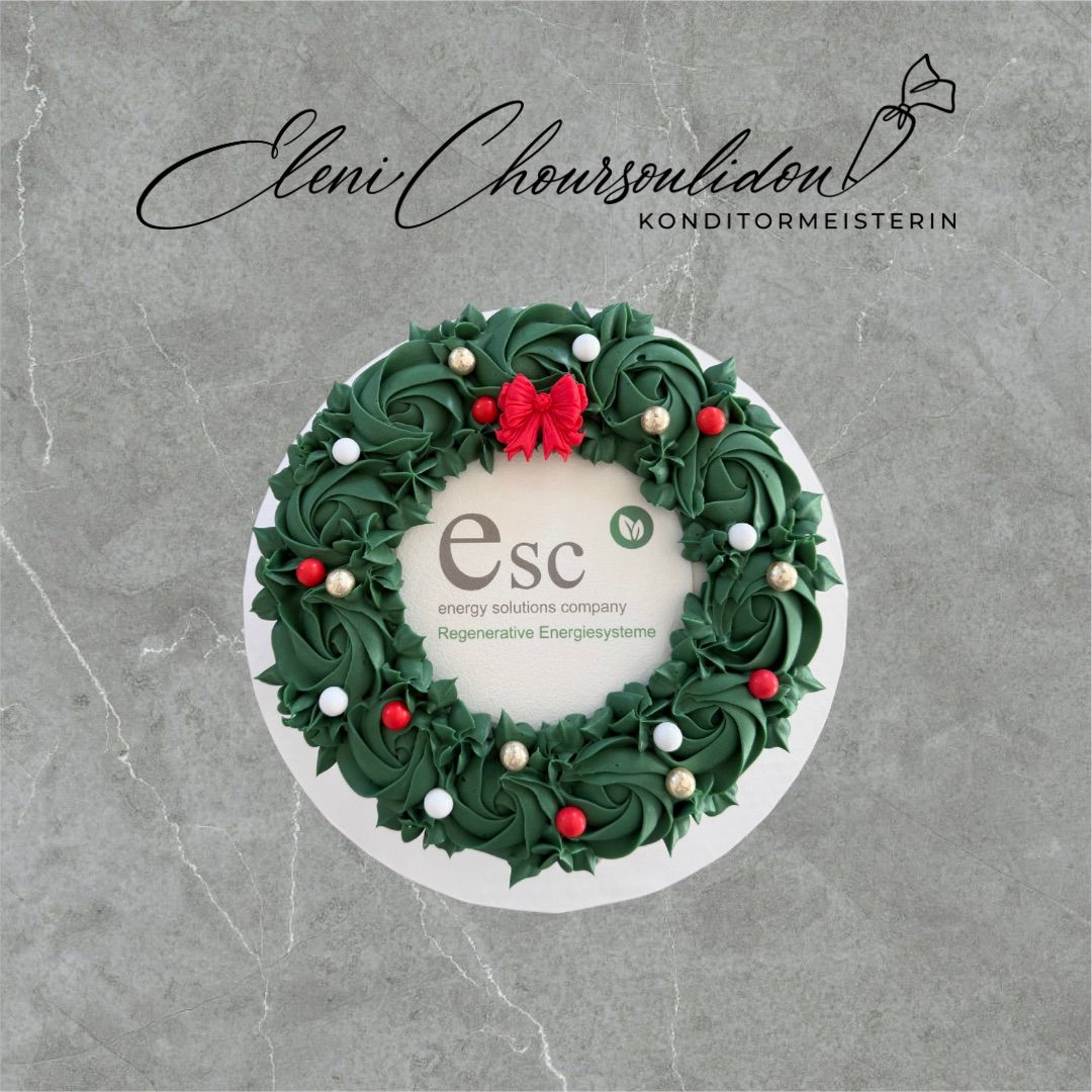 Ein wunderschön gestalteter Weihnachtskranzkuchen, geschmückt mit grünen und roten Dekorationen, ruht auf einer grauen Marmoroberfläche. Der Kuchen ist mit einer roten Schleife verziert und trägt das Logo des Energieunternehmens, Regenerative Energiesysteme.