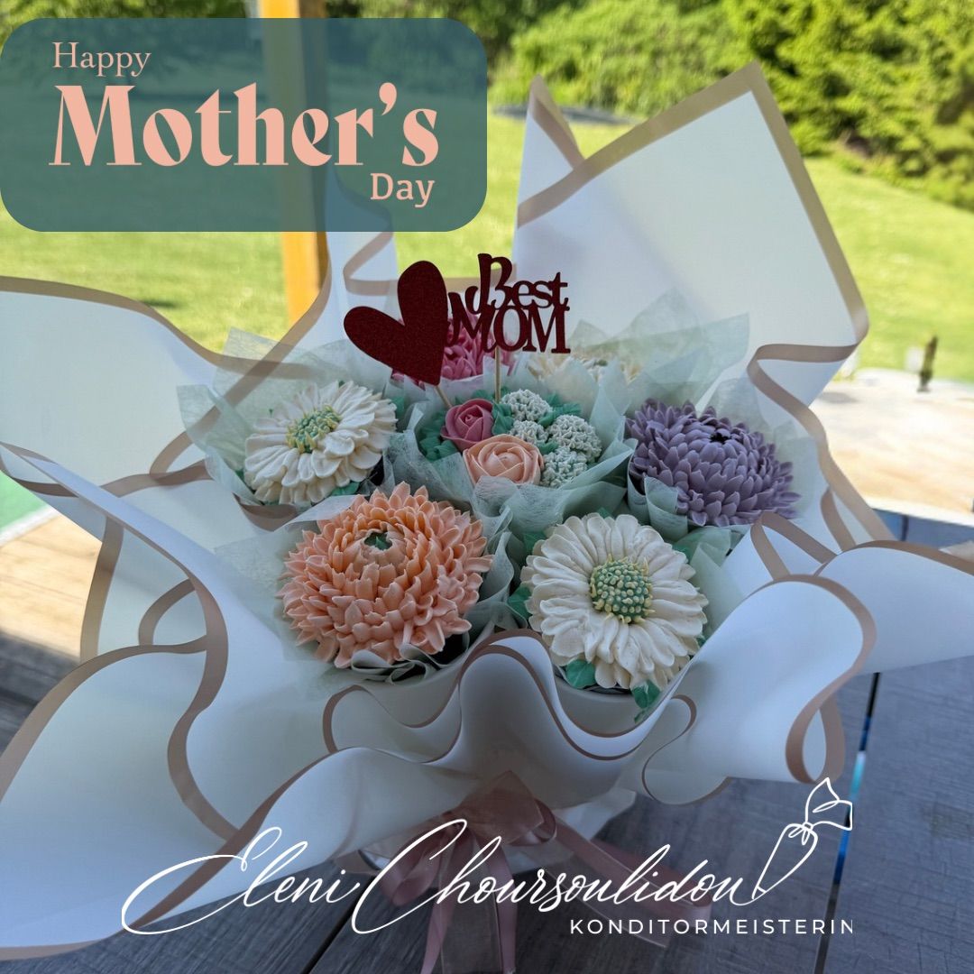 A bouquet of colorful sugar flowers wrapped in a white paper with a ribbon, a red heart, and the words 'Best Mom' on top. The bouquet is placed on a wooden surface.