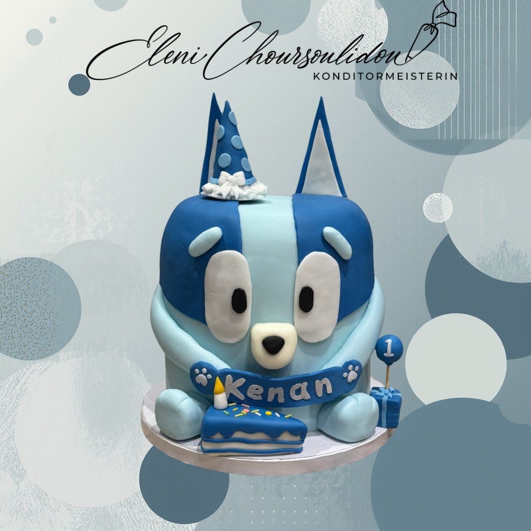 A blue bear cake with a party hat, a candle on a small cake, and the name Kenan written on the cake.