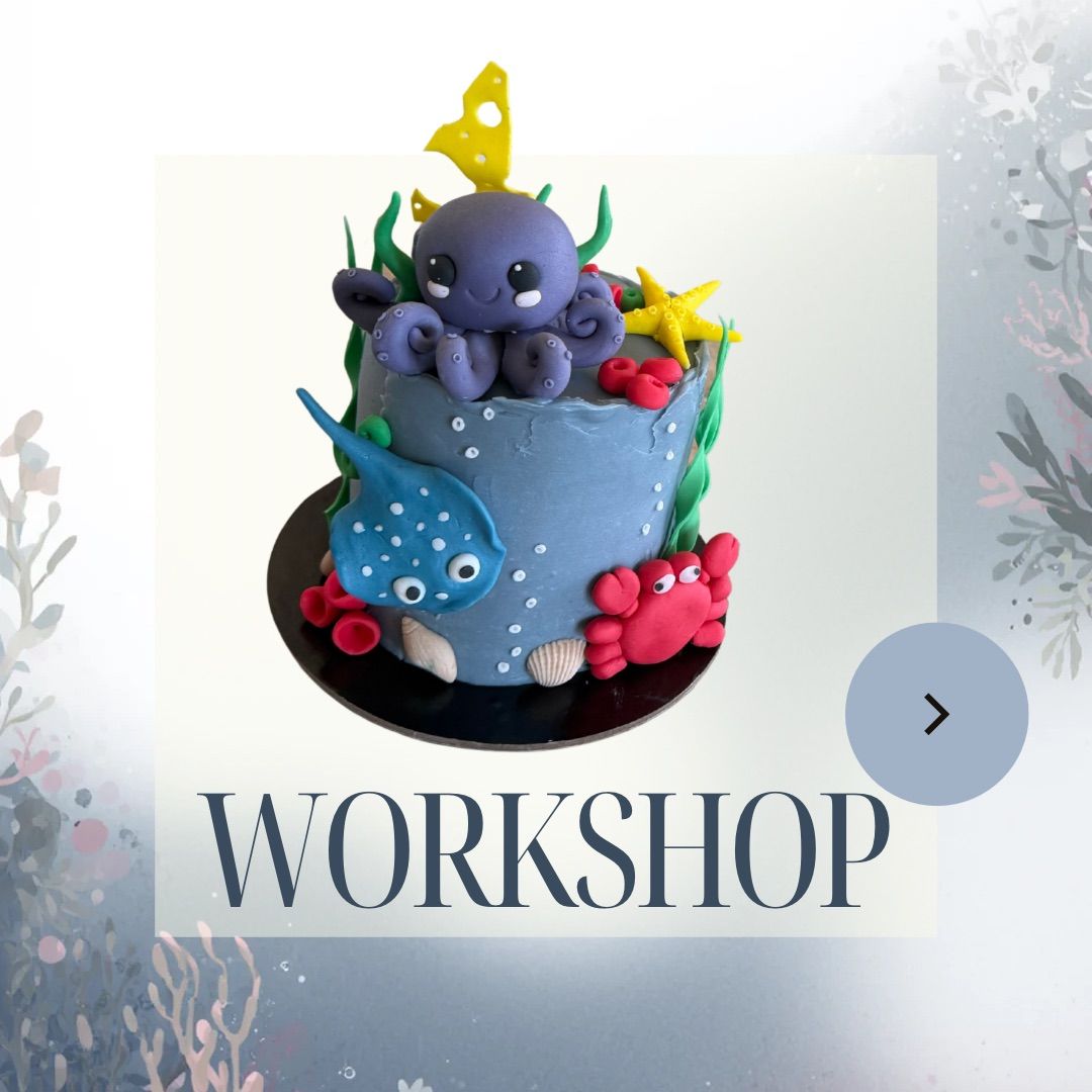 An underwater themed cake with colorful decorations, including an octopus and starfish, on a workshop banner.