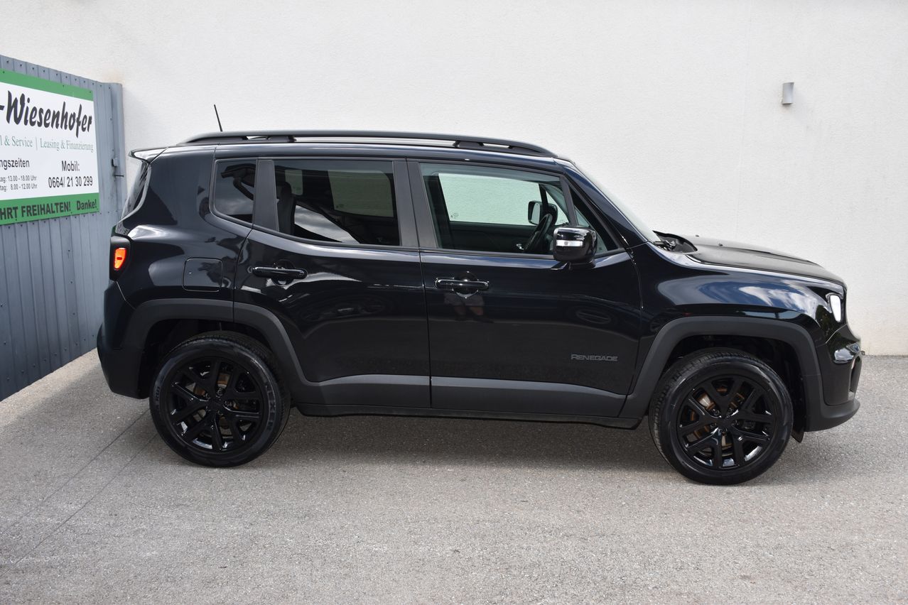 Ein schwarzer Jeep Renegade steht vor einer weißen Wand. Das Fahrzeug hat dunkle Alufelgen und der vordere Stoßfänger hat eine markante schwarze Oberfläche.