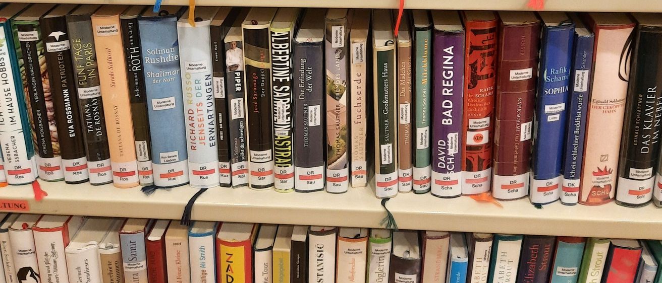 Bild enthält, Shelf, Book, Indoors, Library, Publication, Furniture, Person, Bookcase