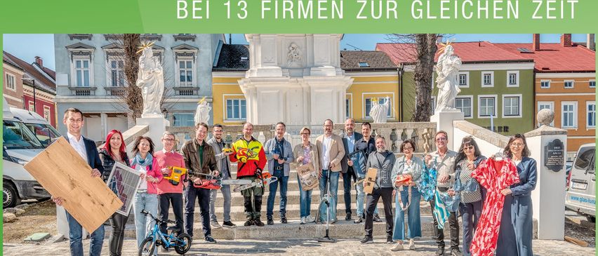 Plakat für Hausmessen 2025 in Waidhofen, Österreich. Eine Gruppe von Menschen posiert vor einem historischen Gebäude und hält verschiedene Gegenstände in den Händen.