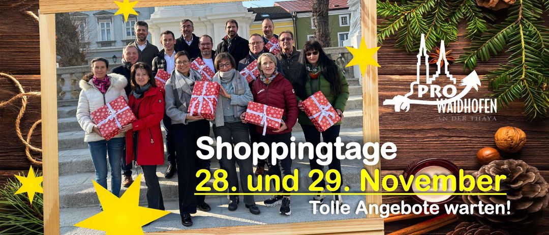 Gruppenfoto mit verpackten Geschenken vor einem Gebäude, Text lautet 'Shoppingtage 28. und 29. Nov. Tolle Angebote'.