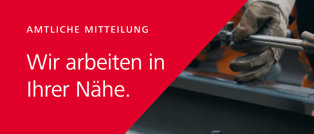 Eine behandschuhte Hand hält ein Metallwerkzeug in einer Werkstatt. Der Hintergrund ist unscharf und konzentriert sich auf das Werkzeug und die Hand.