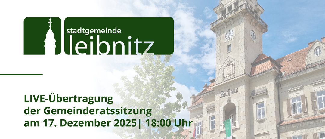 Das Bild zeigt eine Stadtratssitzung im Dezember 2025 um 18:00 Uhr. Im Hintergrund befindet sich ein Uhrturm mit Flaggen und einem Baum.