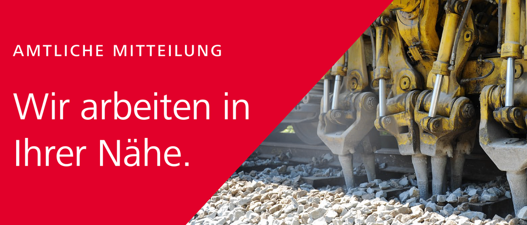 Ein Nahaufnahme eines schweren Maschinenfahrzeugs auf Eisenbahngleisen mit Kies und Steinen darum. Das Fahrzeug hat gelbe Teile.