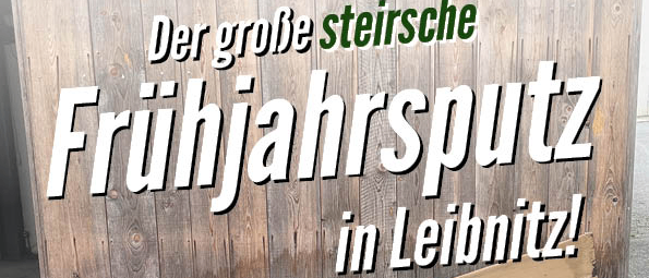 Ein Holzschild in Deutsch lautet 'Der große steirische Frühjahrsputz in Leibnitz!' Am Boden liegen Plastiktüten und Schutt.