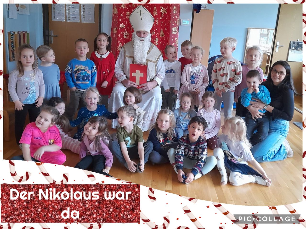 Eine Gruppe von Kindern posiert für ein Foto mit einem Mann, der als St. Nikolaus verkleidet ist, in einer festlichen Umgebung.