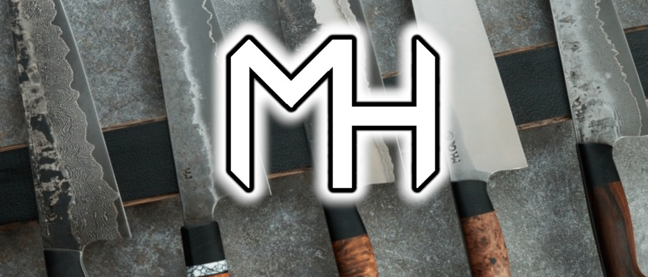 Nahaufnahme mehrerer Messer mit Holzgriffen und dem Logo MH auf einer grauen Oberfläche.