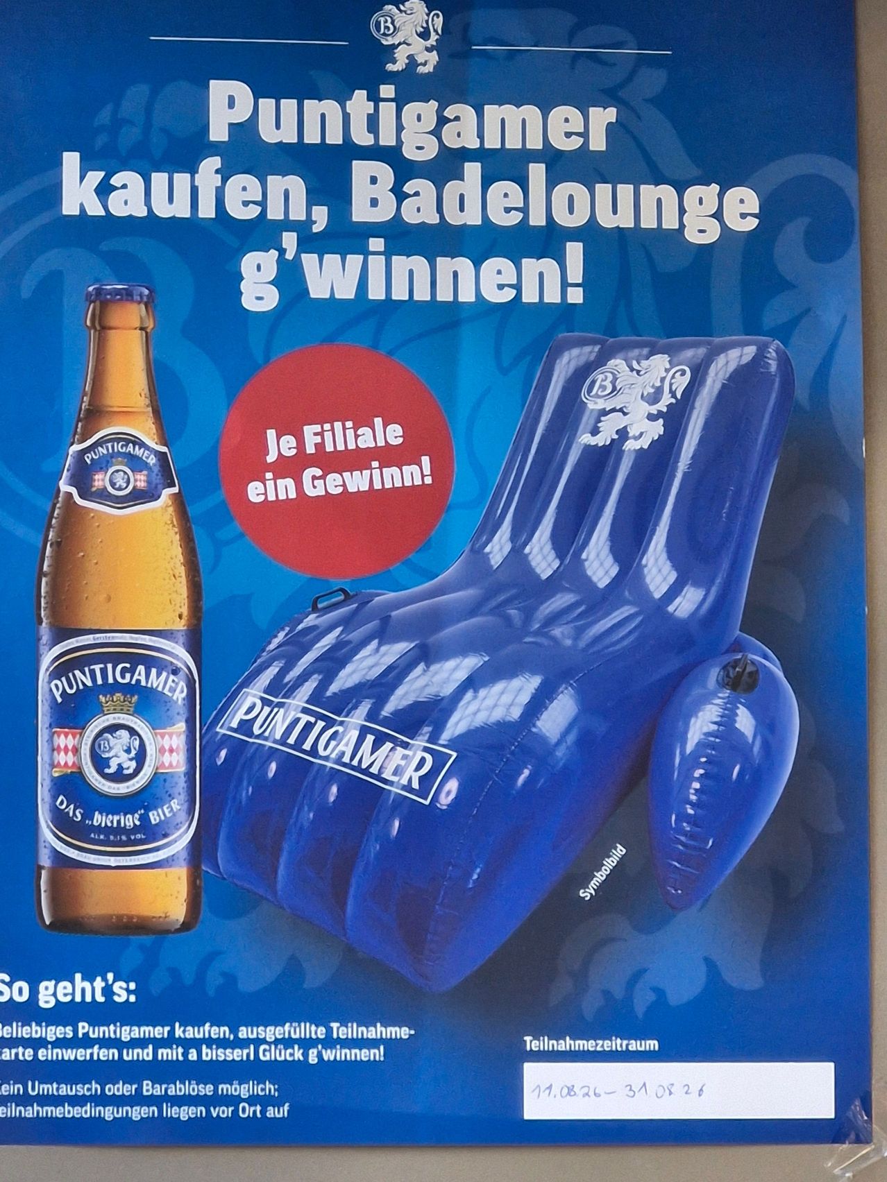 Eine Werbung für Puntigam Bier zeigt eine Flasche und einen aufblasbaren Liegestuhl mit dem Markenlogo. Der Text lautet 'Kaufen, Badelounge, gewinnen!' und 'Je Flasche ein Gewinn!' auf Deutsch.