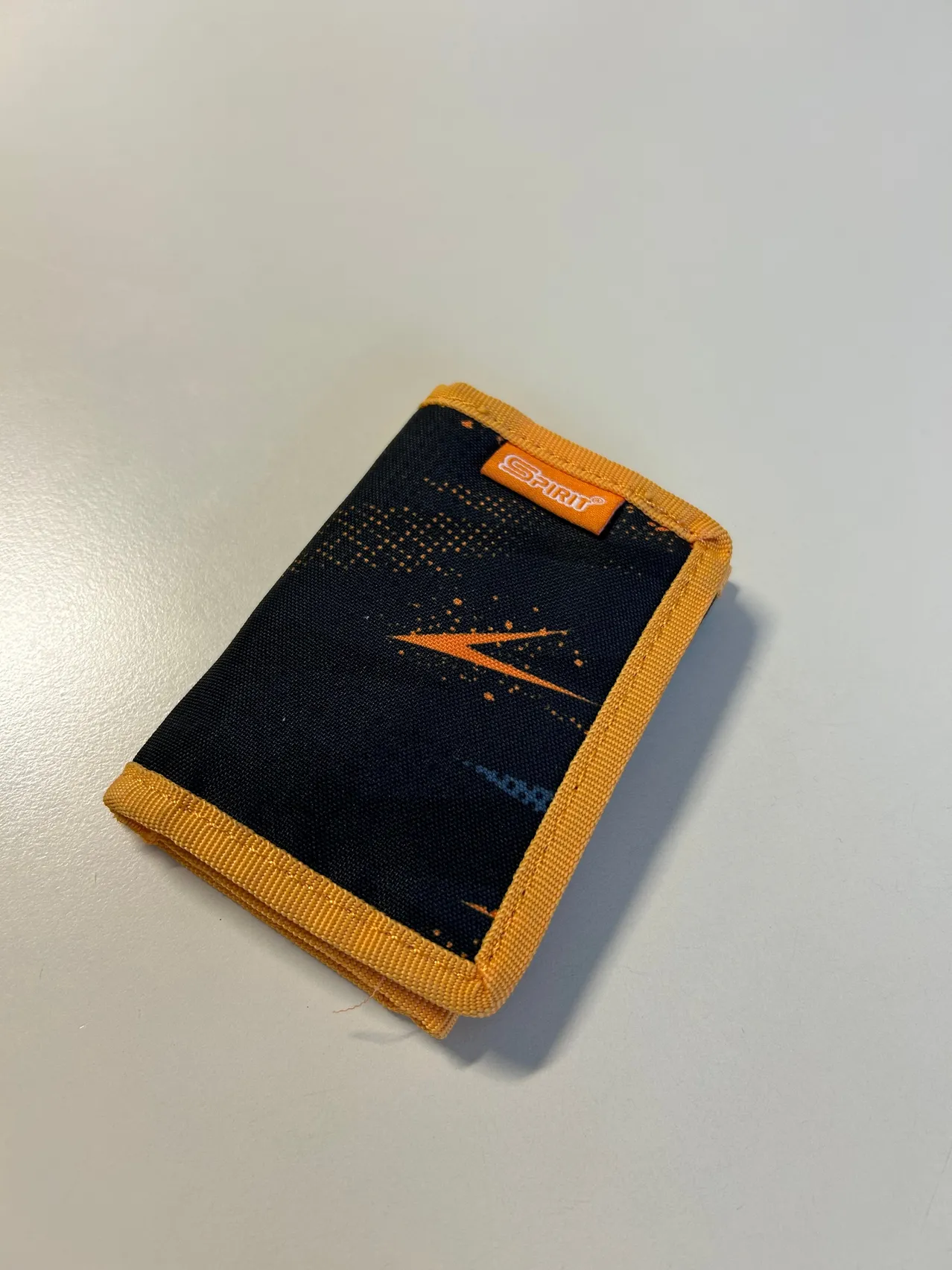 Ein schwarz-oranger Geldbeutel mit einem Blitzdesign.