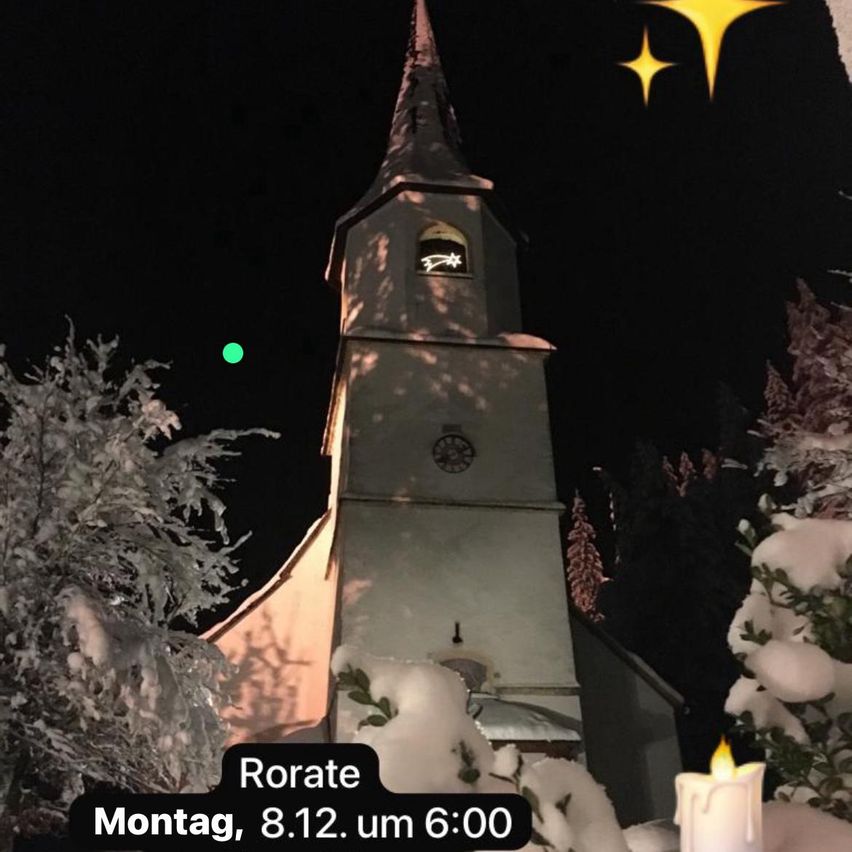 Eine Nachtansicht einer Kirche mit Turm, Uhr und brennender Kerze. Schnee bedeckt die umliegenden Bäume und den Boden. Der Text 'Rorate' und ein Datum 'Montag, 8.12.' sind angezeigt.