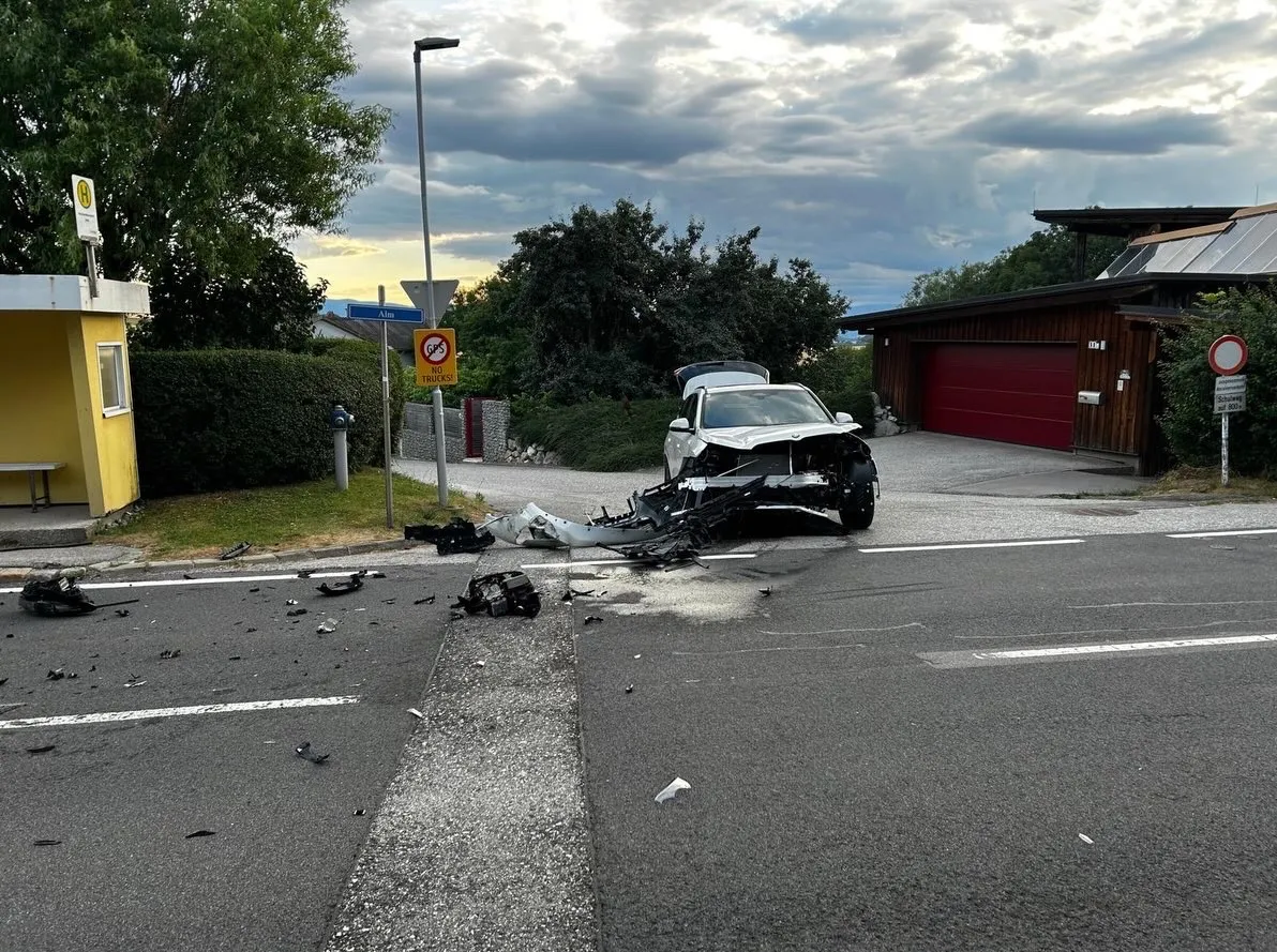 Ein Auto ist auf einer Straße mit verstreuten Trümmern in der Nähe einer Straßenlaterne und eines Schildes kaputt.