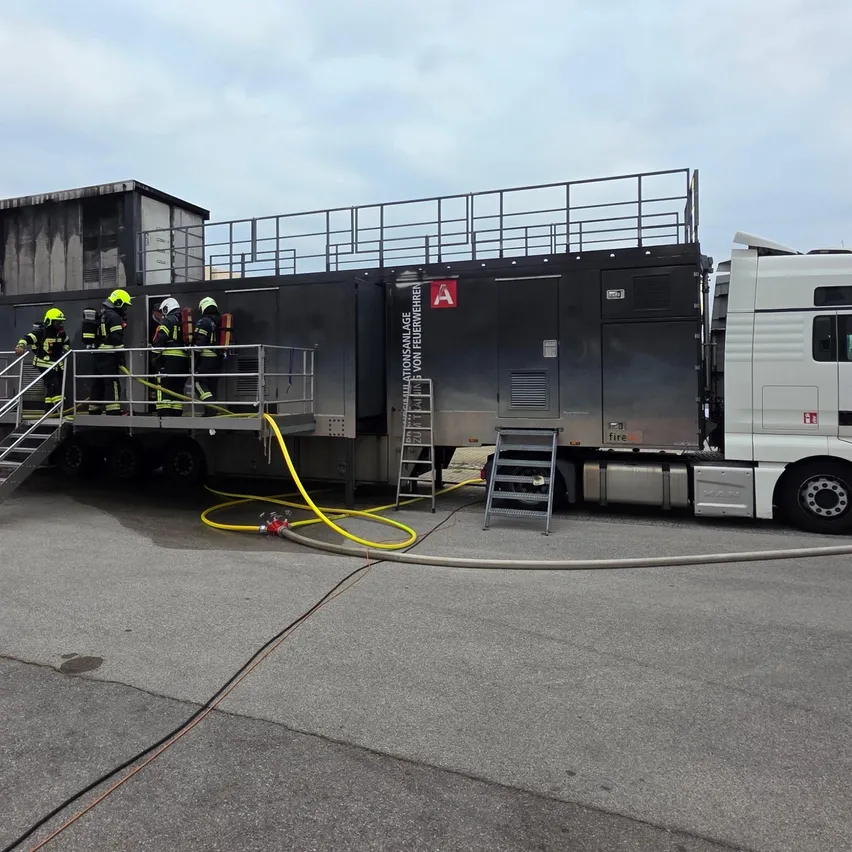Ein Feuerwehr-Trainingsfahrzeug mit Feuerwehrleuten auf den Treppen.