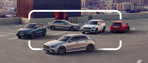 Verschiedene Autos sind auf einem Parkplatz in der Stadt geparkt, mit einer Kulisse von Hochhäusern unter einem klaren Himmel.